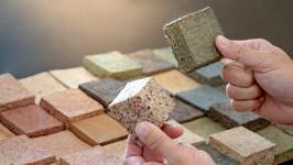 Handen vergelijken verschillende stalen van bouwmaterialen met uiteenlopende samenstellingen.