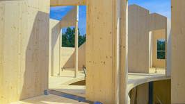 Houten gebouw in opbouw met massieve prefab wand- en vloerelementen.